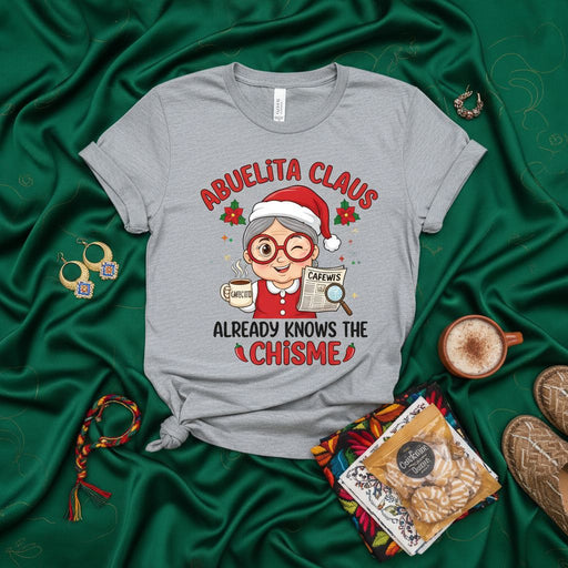 Abuelita Claus Already Knows The Chisme Christmas T-Shirt - Funny Spanish English Holiday Tee with Grandma, Cafecito, and a Winking Abuela in a Santa Hat for Latino Families Mexicada