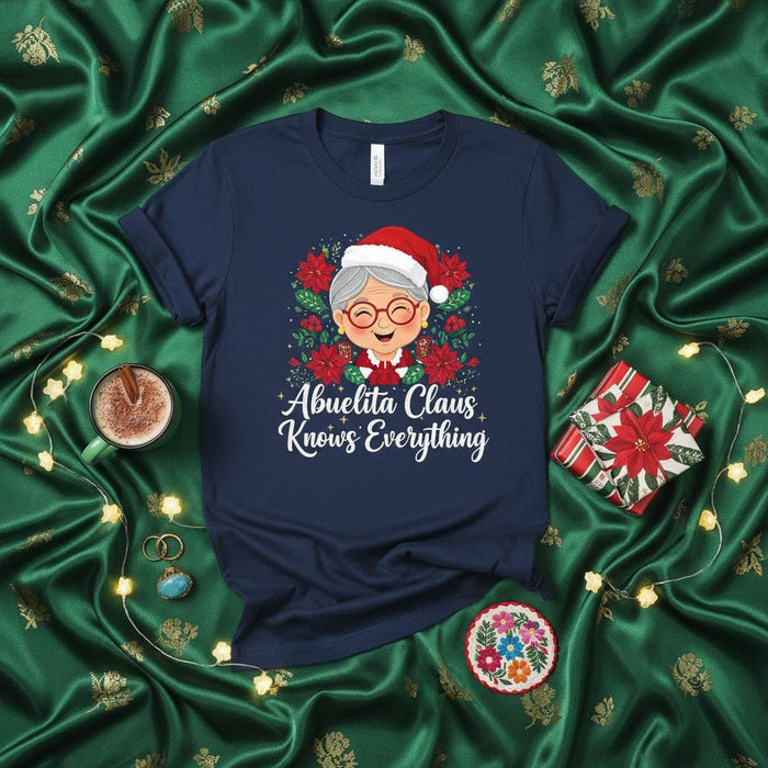 Abuelita Claus Knows Everything Christmas T-Shirt, Cute Grandma Santa Poinsettia Wreath Tee, Holiday Gift for Abuela, Funny Spanish English Mixed Text Shirt Mexicada