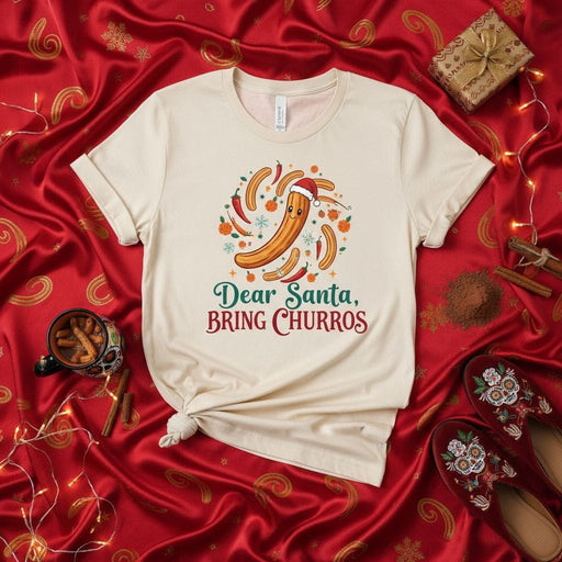 Dear Santa, Bring Churros Funny Christmas T-Shirt, Holiday Foodie Tee with Santa Hat Churro Design, Unisex Festive Dessert Lover Shirt for Winter Season, Cute Gift for Snack Enthusiasts Mexicada
