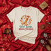 Dear Santa, Bring Churros Funny Christmas T-Shirt, Holiday Foodie Tee with Santa Hat Churro Design, Unisex Festive Dessert Lover Shirt for Winter Season, Cute Gift for Snack Enthusiasts Mexicada
