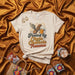 Fueled by Chela and Chancla Trauma T-Shirt, Funny Hispanic Latino Culture Shirt, Spanglish Drinking Beer Tee, Chanclas with Wings Graphic Top Mexicada